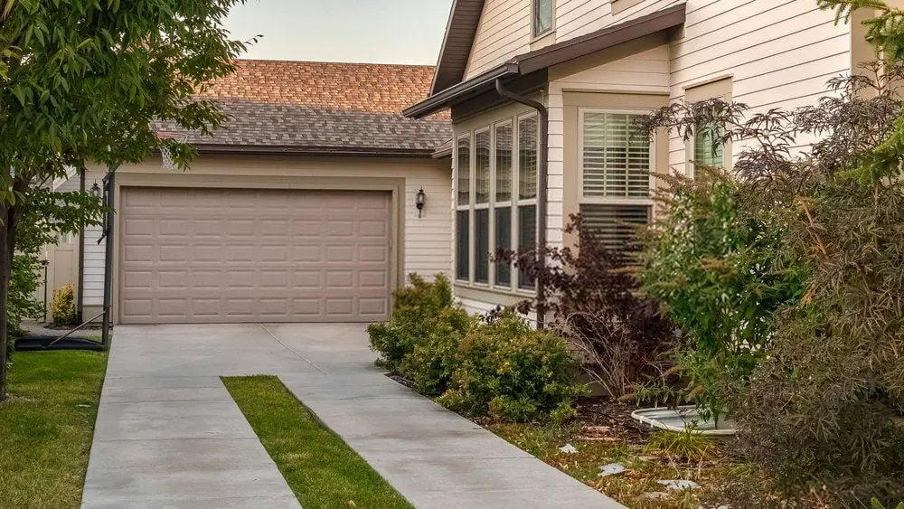 concrete and artificial grass driveway in Minden, NV leading to a closed garage