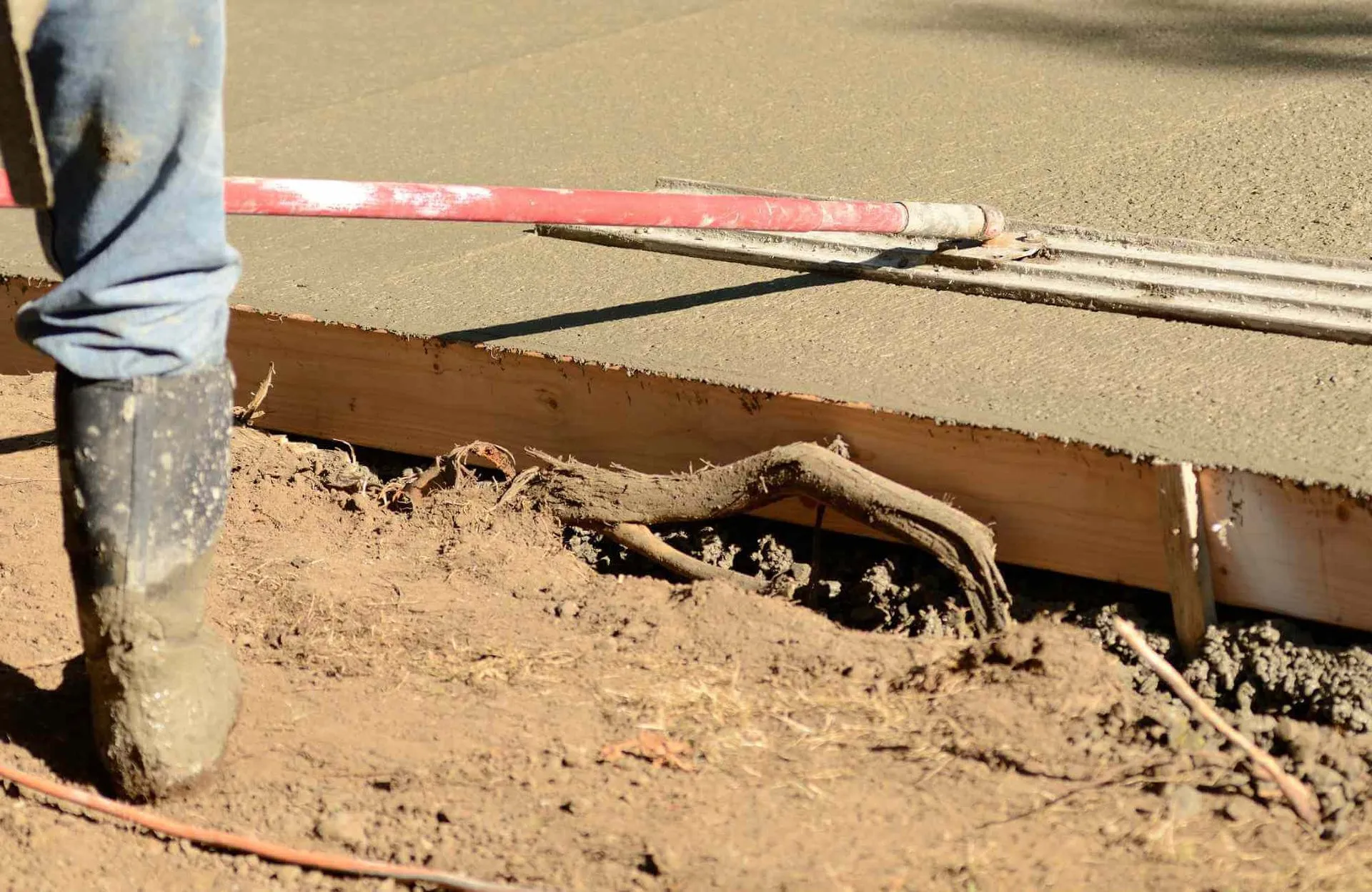 the newly poured concrete mix is being leveled by a local contractor to create a smooth finish